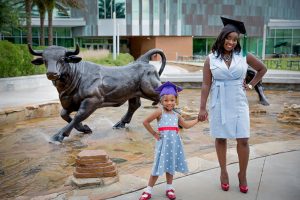Herlende st. phaird and daughter in front of bull sculpture water fountain at USF