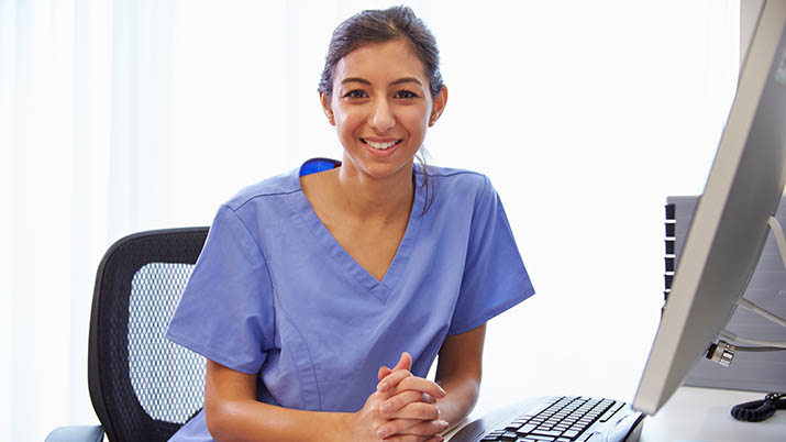 medical professional sitting in front of a computer