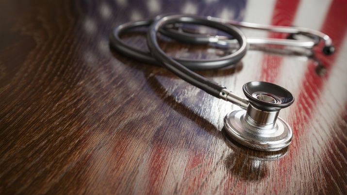 An american flag and stethoscope on a shiny desk depicting the HITECH Act