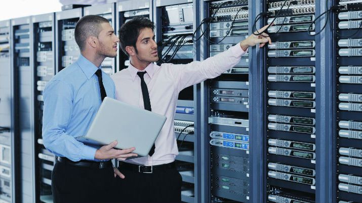 two guys looking at server racks discussing the differences between mis and health informatics