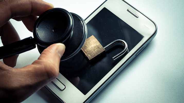 hand using a stethoscope to check smartphone system - checking security on smartphone concept symbolizing protected health information