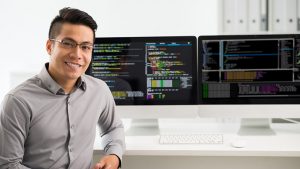Portrait of smiling young Vietnamese software engineer working in healthcare information technology