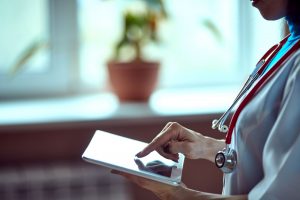 Female medical professional using SAS healthcare software on a tablet device