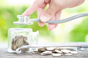 a stethoscope being held over an overturned coin jar