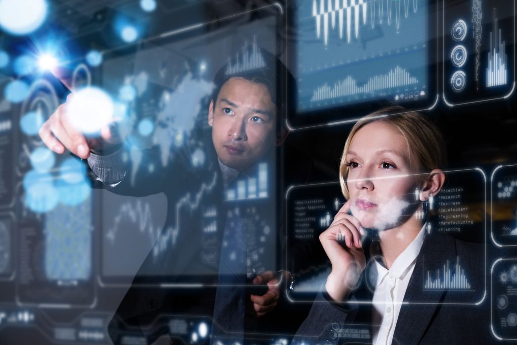 two young people sitting behind and interacting with a lightboard with health data