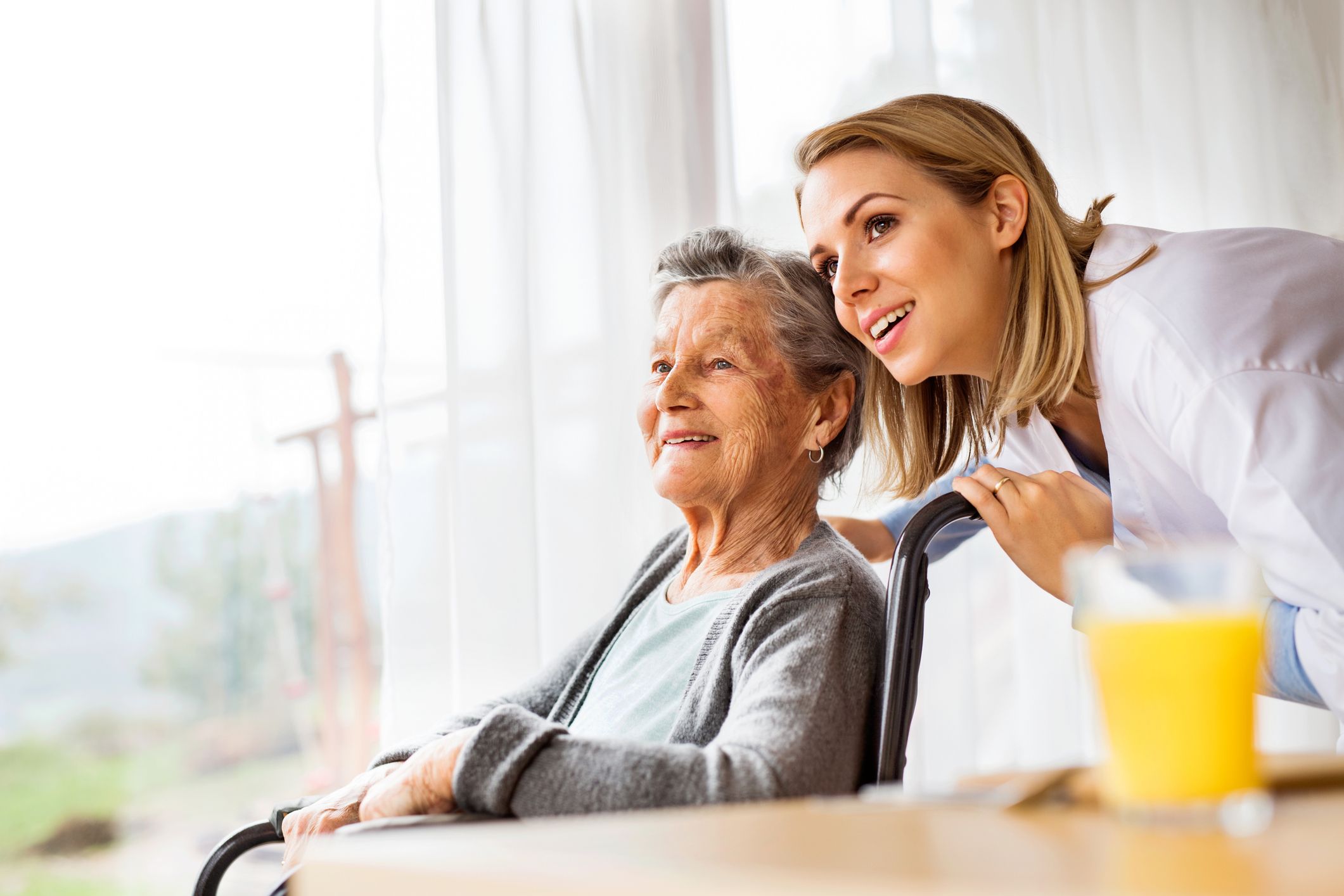 a young female medical professional with an elderly woman in a wheel chair