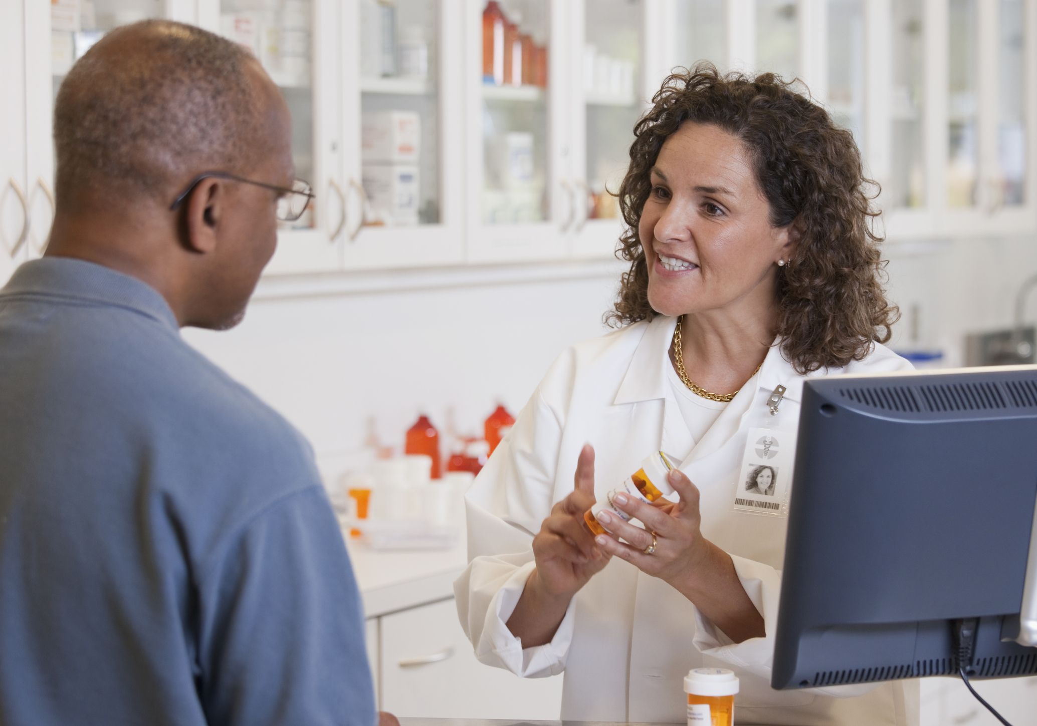 a female pharmacist explaining medication to an older man