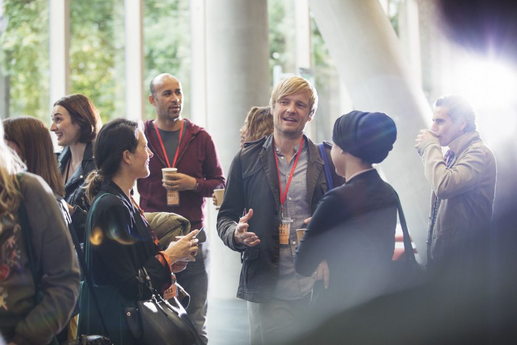 a man networking with other young people at a conference