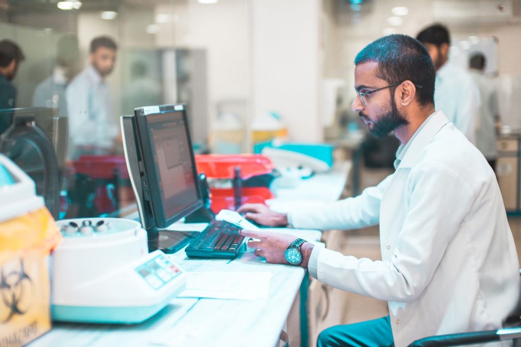 A lab attendant works on the computer. Find out more about laboratory informatics.