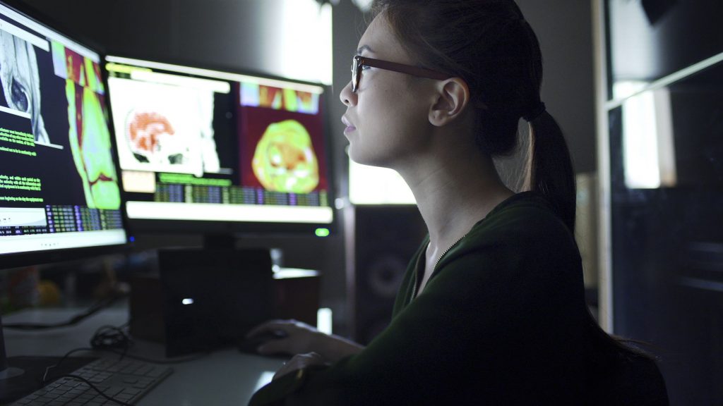 A female data analyst examines data visualizations.