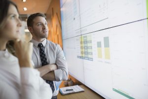 Professionals examine an analytics dashboard.