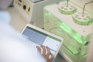 Image depicting a healthcare data scientist in a lab holding a tablet device