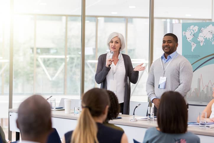 Healthcare professionals speaking at a conference session.